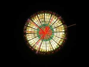 An LHC proton-proton collision superimposed on the Dallas Hall stained-glass window.