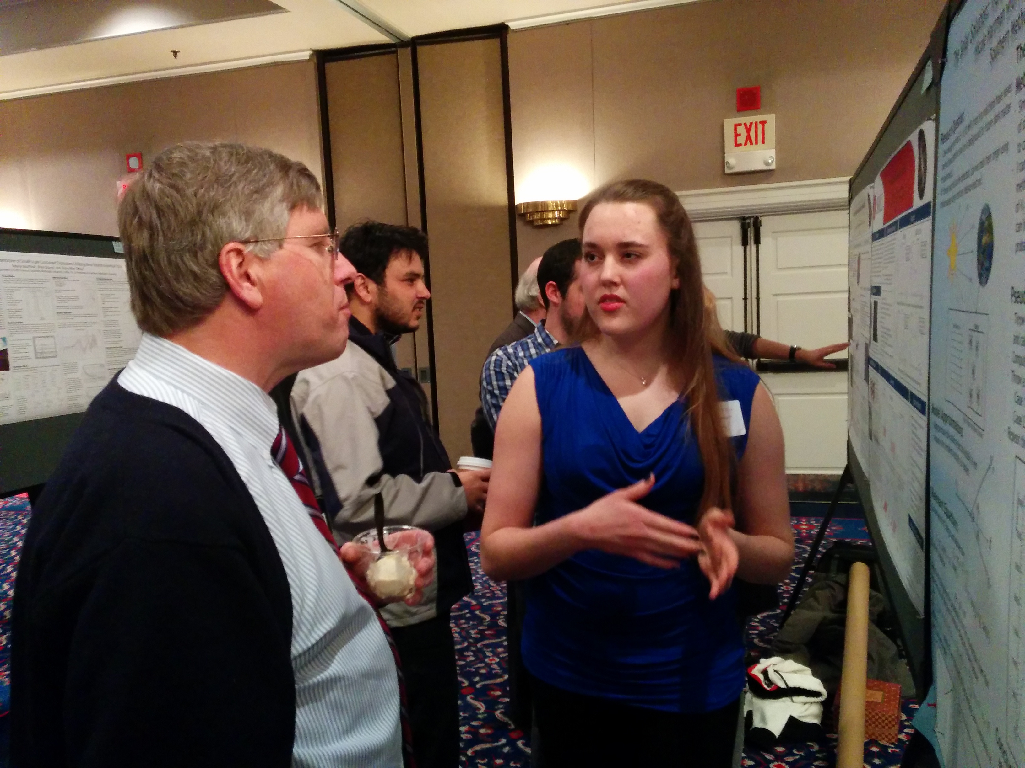 SMU undergraduate Nicole Hartman (right) explains her simulation of low-energy neutrinos scattering to Prof. Fred Olness, Chair of the SMU Department of Physics. Photo taken at SMU Research Day, 2015.