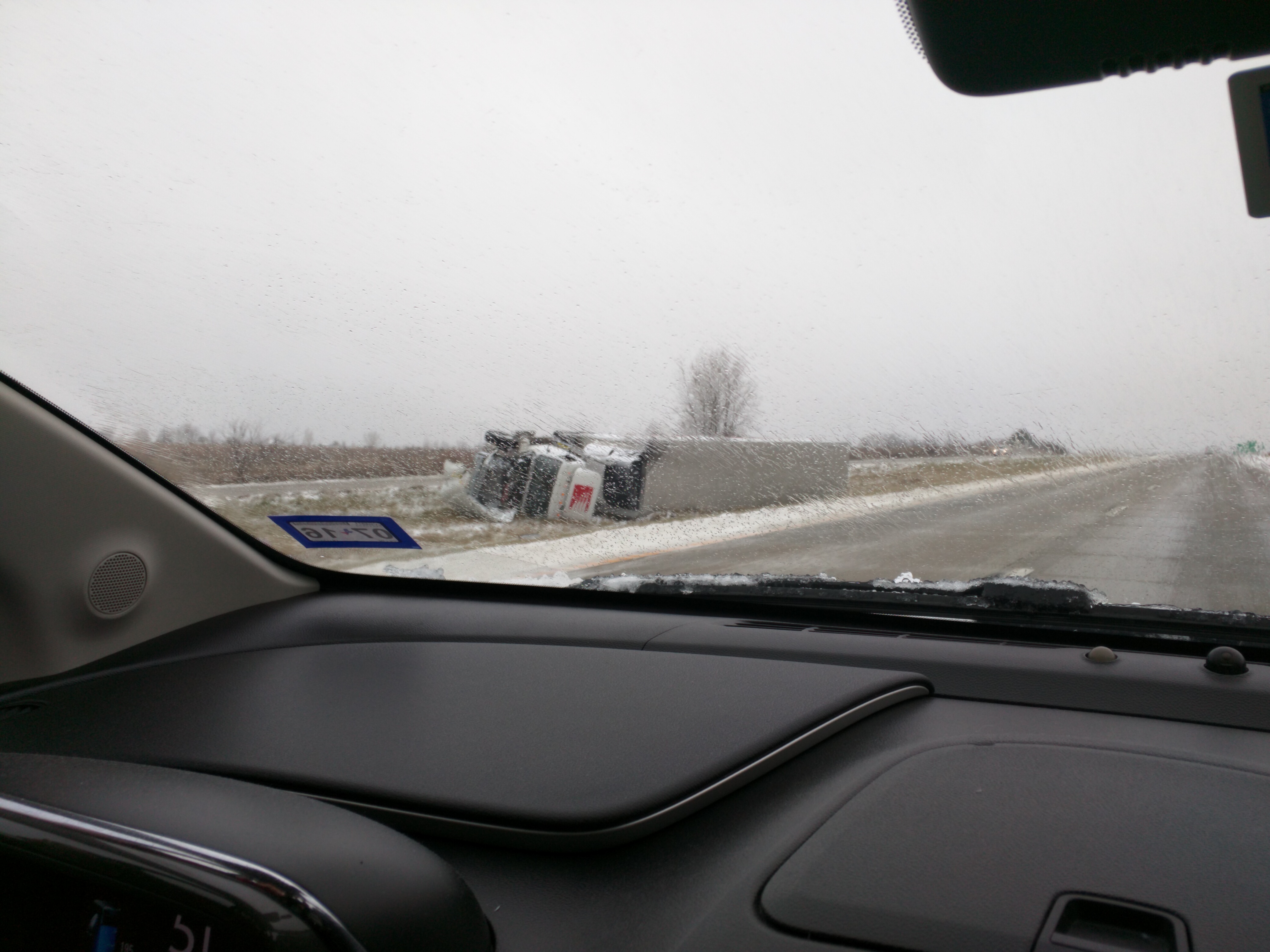 A toppled tractor trailer truck lying in the median ditch of I-35, a victim of the forces of nature parading through the central United States this week.