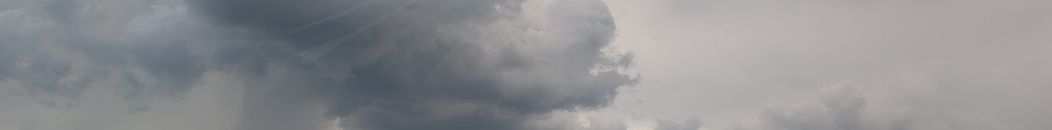 Rain is seen falling in the distance as we pass into a region with mixed weather.