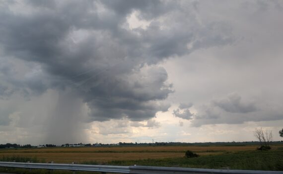 Rain is seen falling in the distance as we pass into a region with mixed weather.