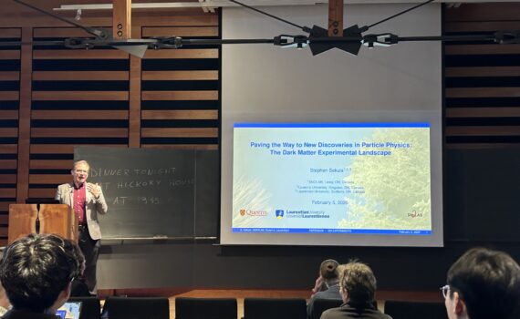 A person standing on a stage presenting a slide deck.